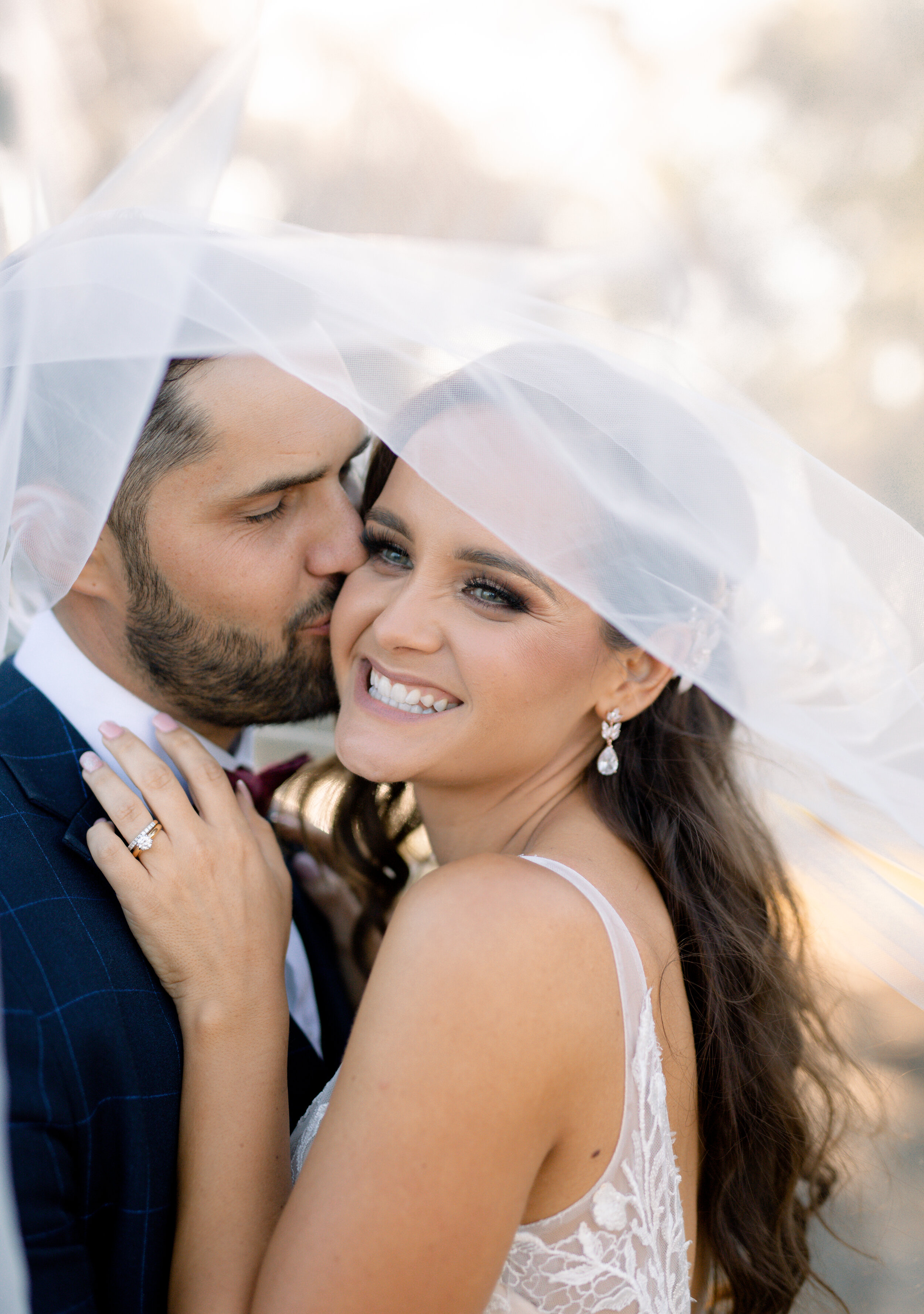 groom kissing bride on the cheek 