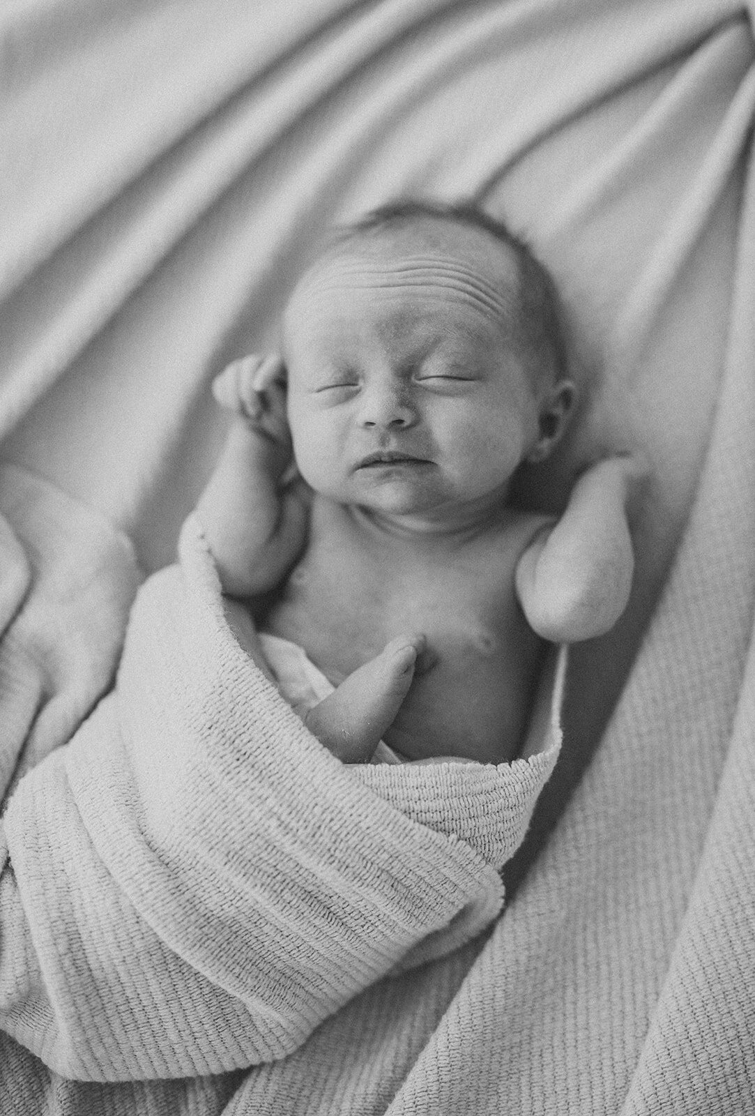 black and white photograph of a newborn baby's sleepy stretch