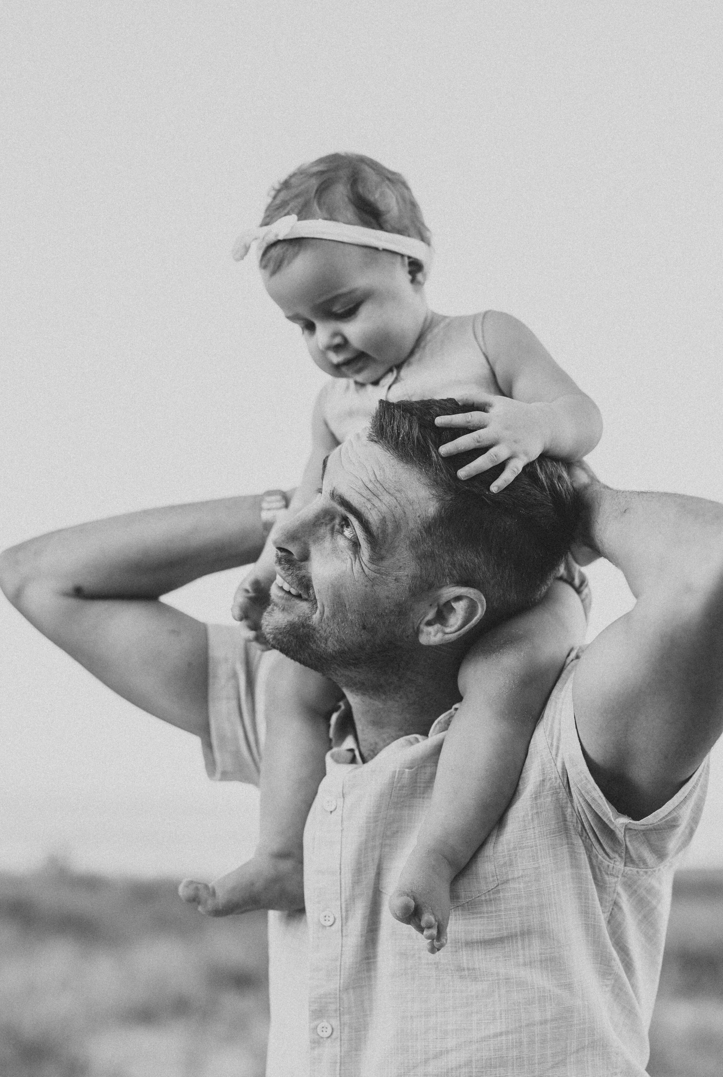 Little girl sitting on her father's shoulders