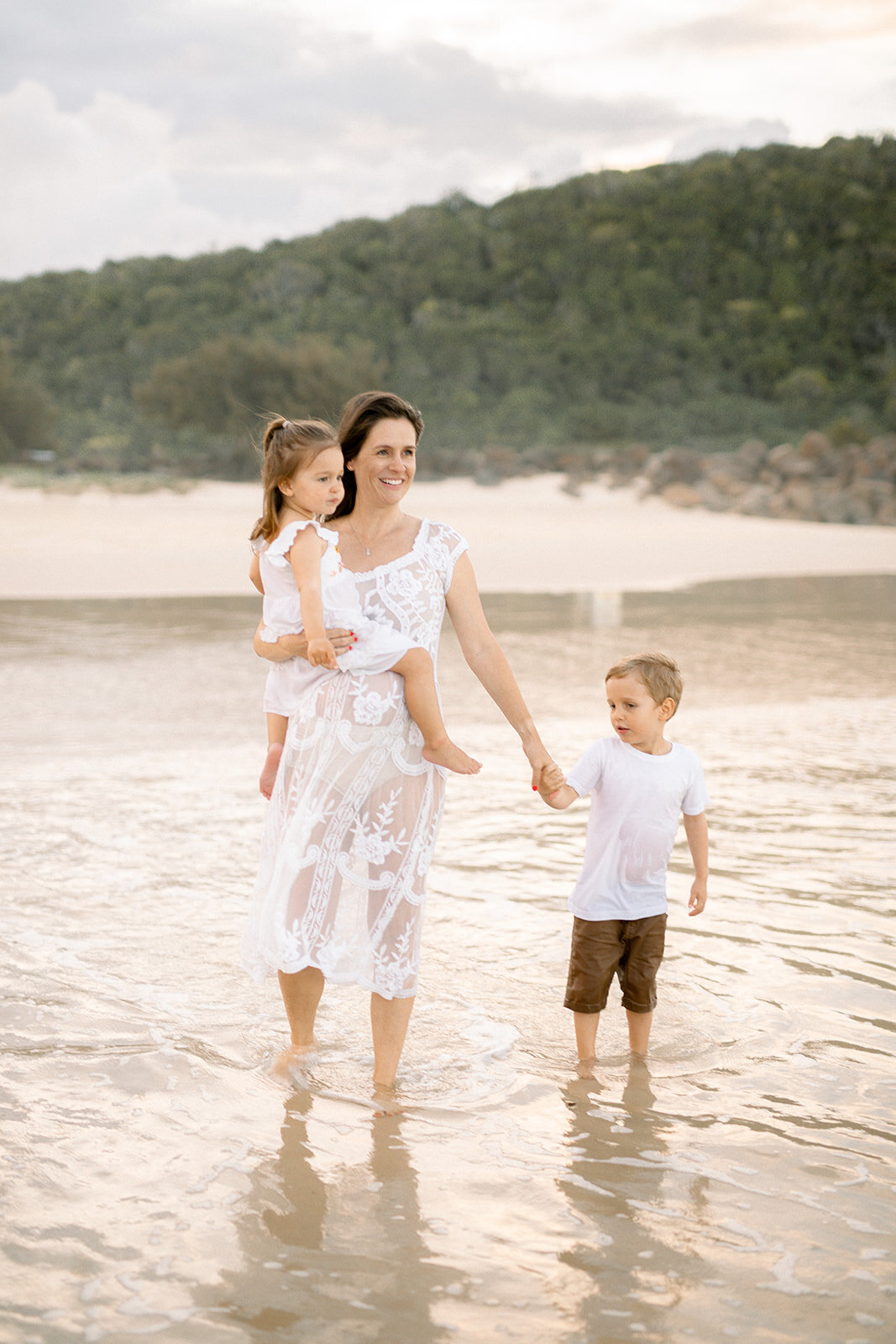 Mother and her children walking on the beach