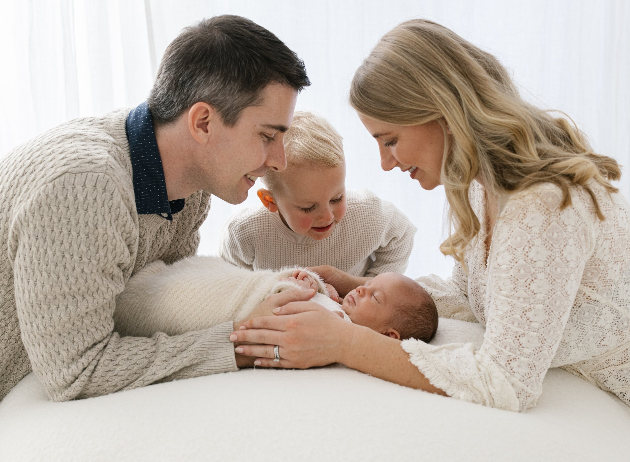 newborn baby surrounded by family in brisbane newborn studio