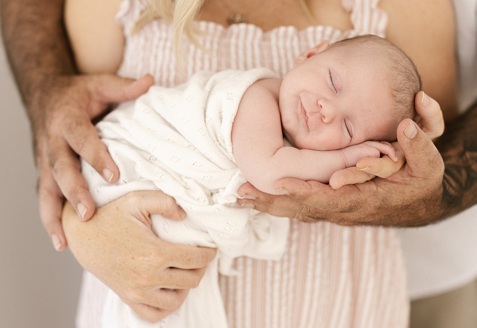 Mum and Dad cradling sleeping newborn