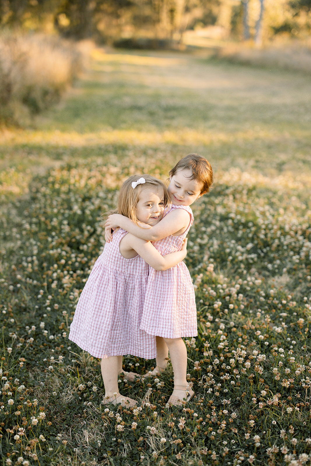 Twin sisters standing together giving each other a hug