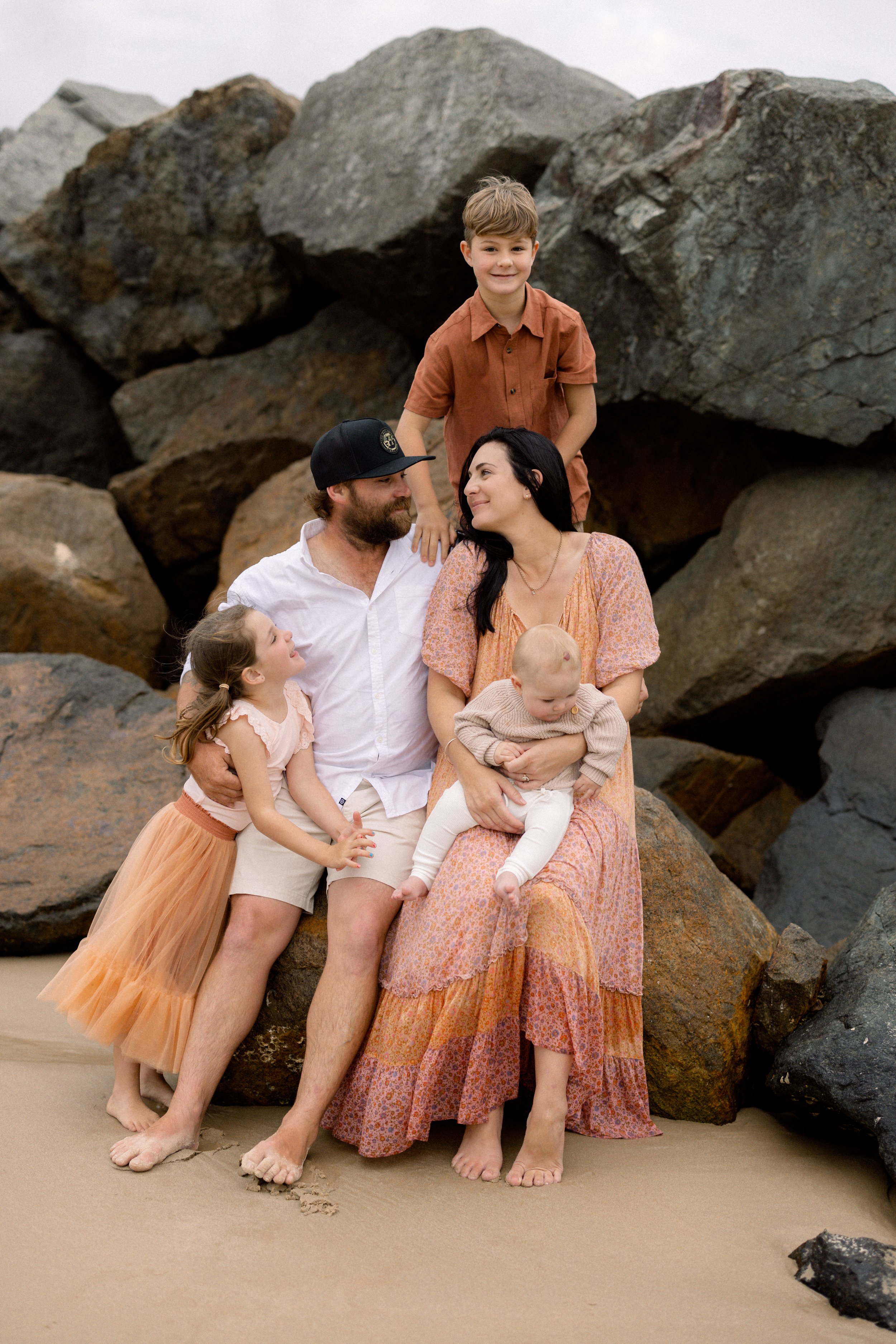 family of 5 sitting on rocks at Noosa Sunshine Coast