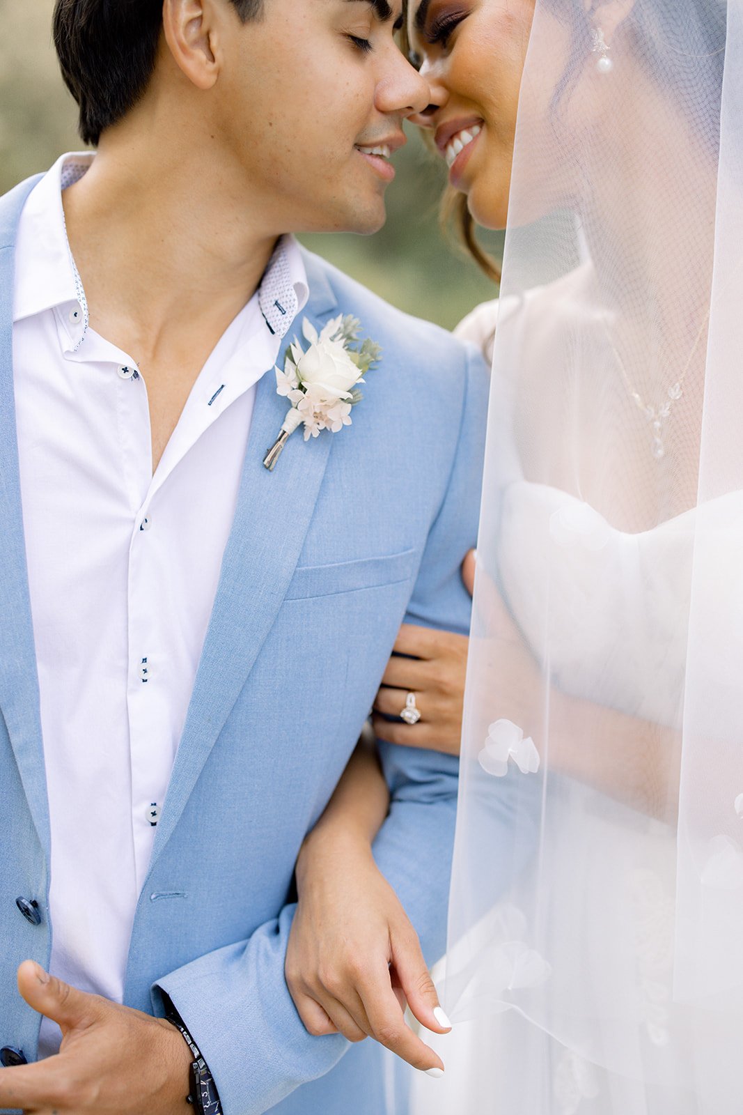 Bride and Groom close together under a bridal veil