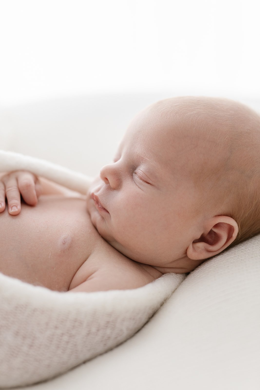 Close up of a newborn baby with strawberry blonde hair