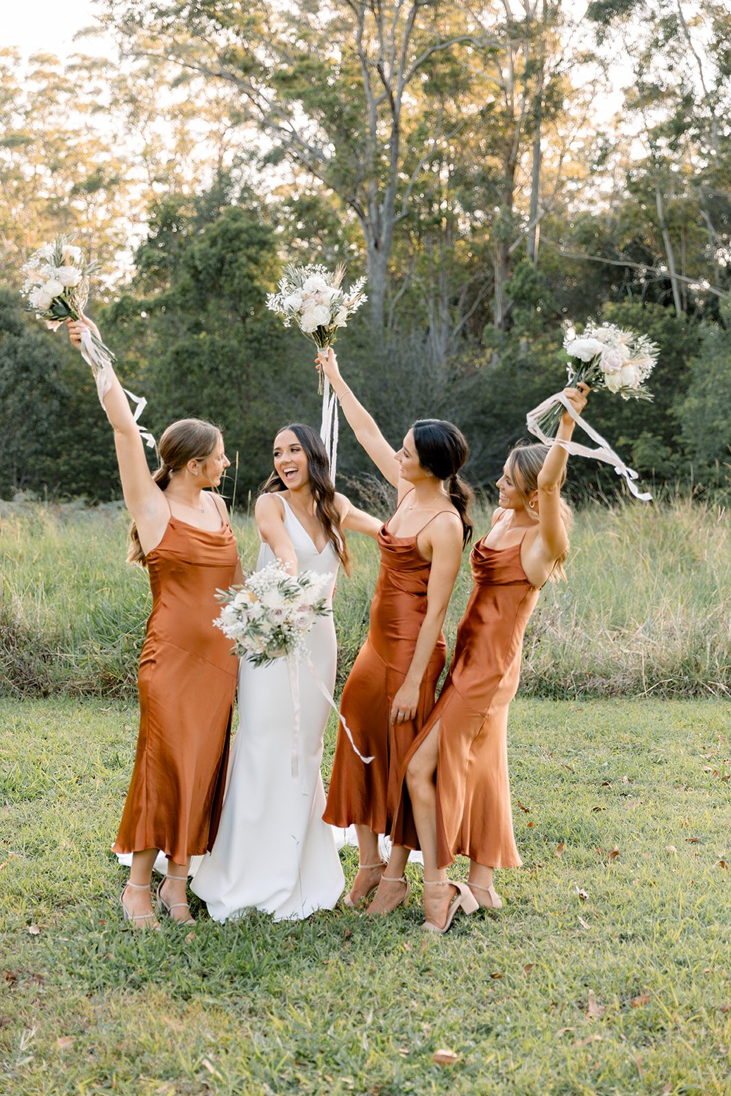 Bride and bridesmaids throwing bouquets in the air having fun