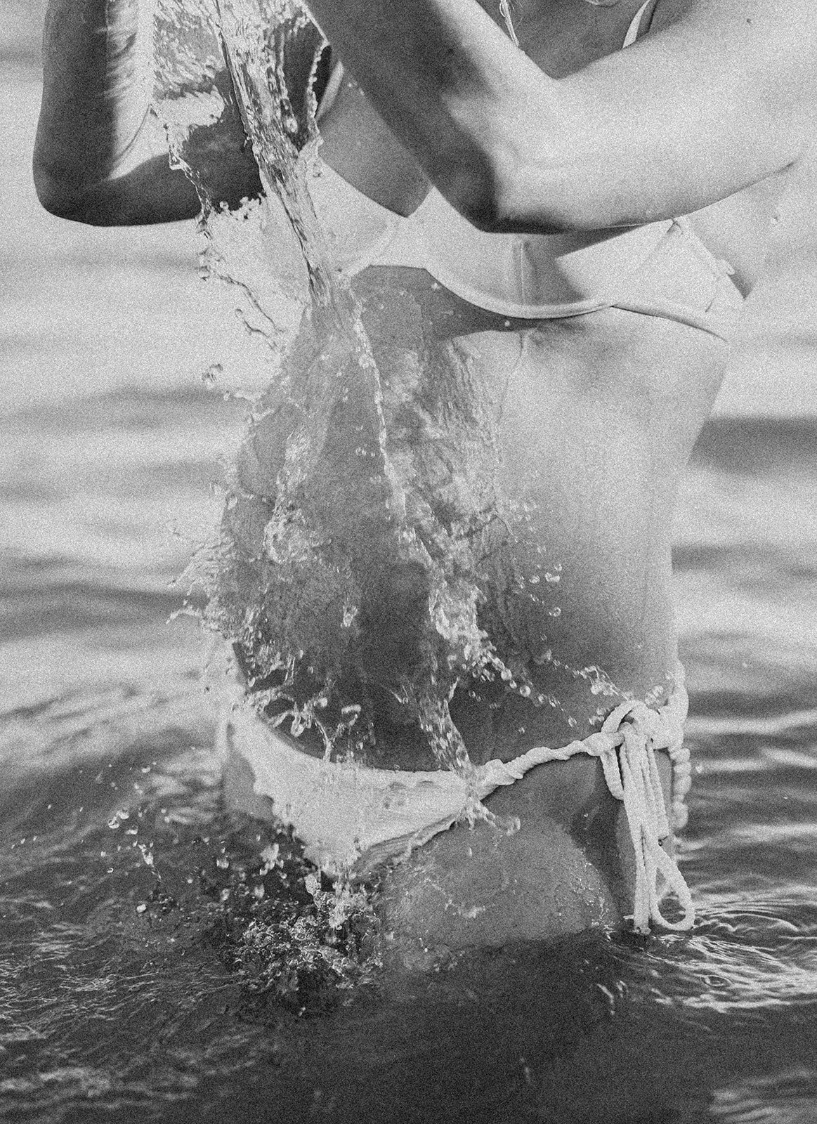 Close up in of a pregnancy belly and splashes of water at the beach