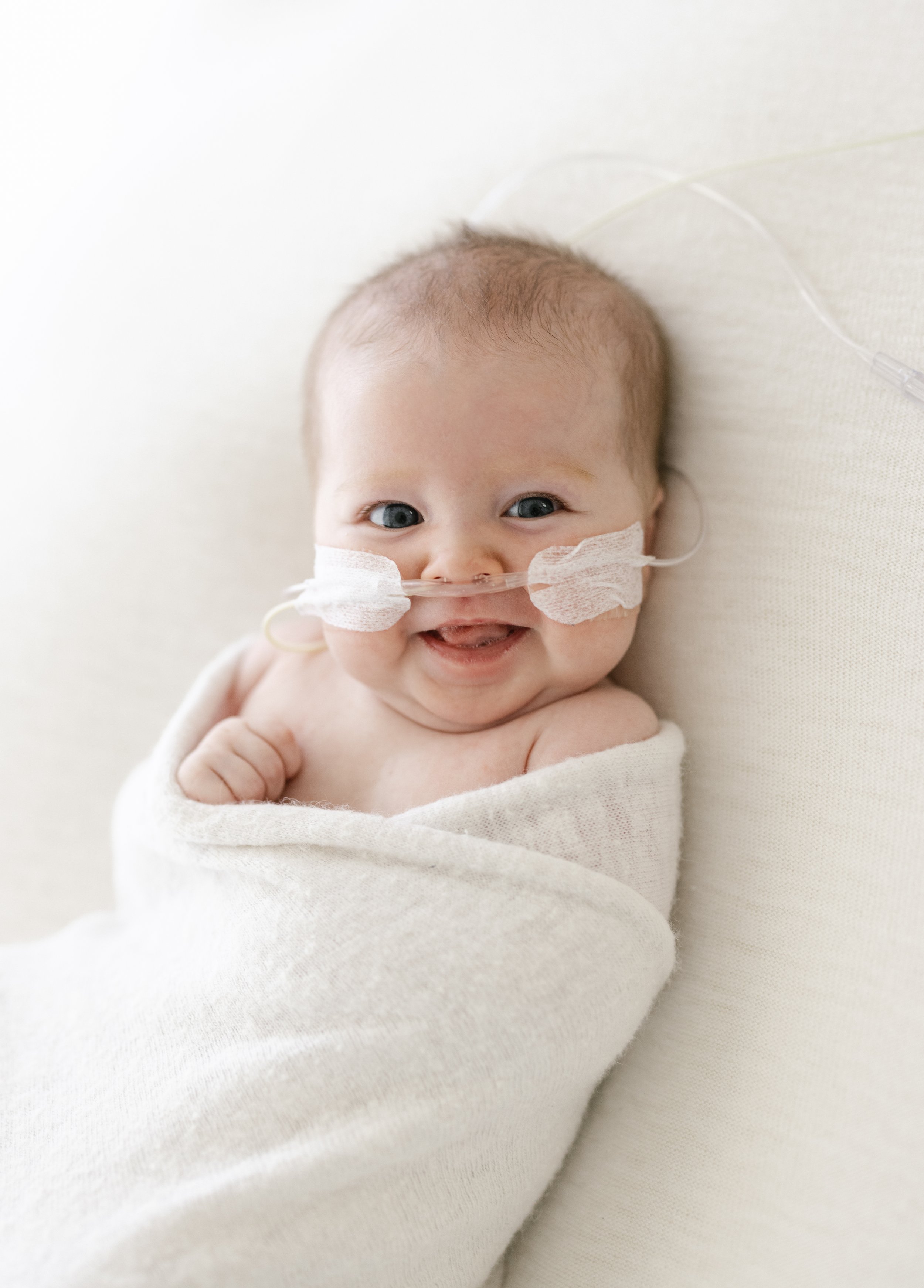 newborn baby girl smiling in her newborn photographs 