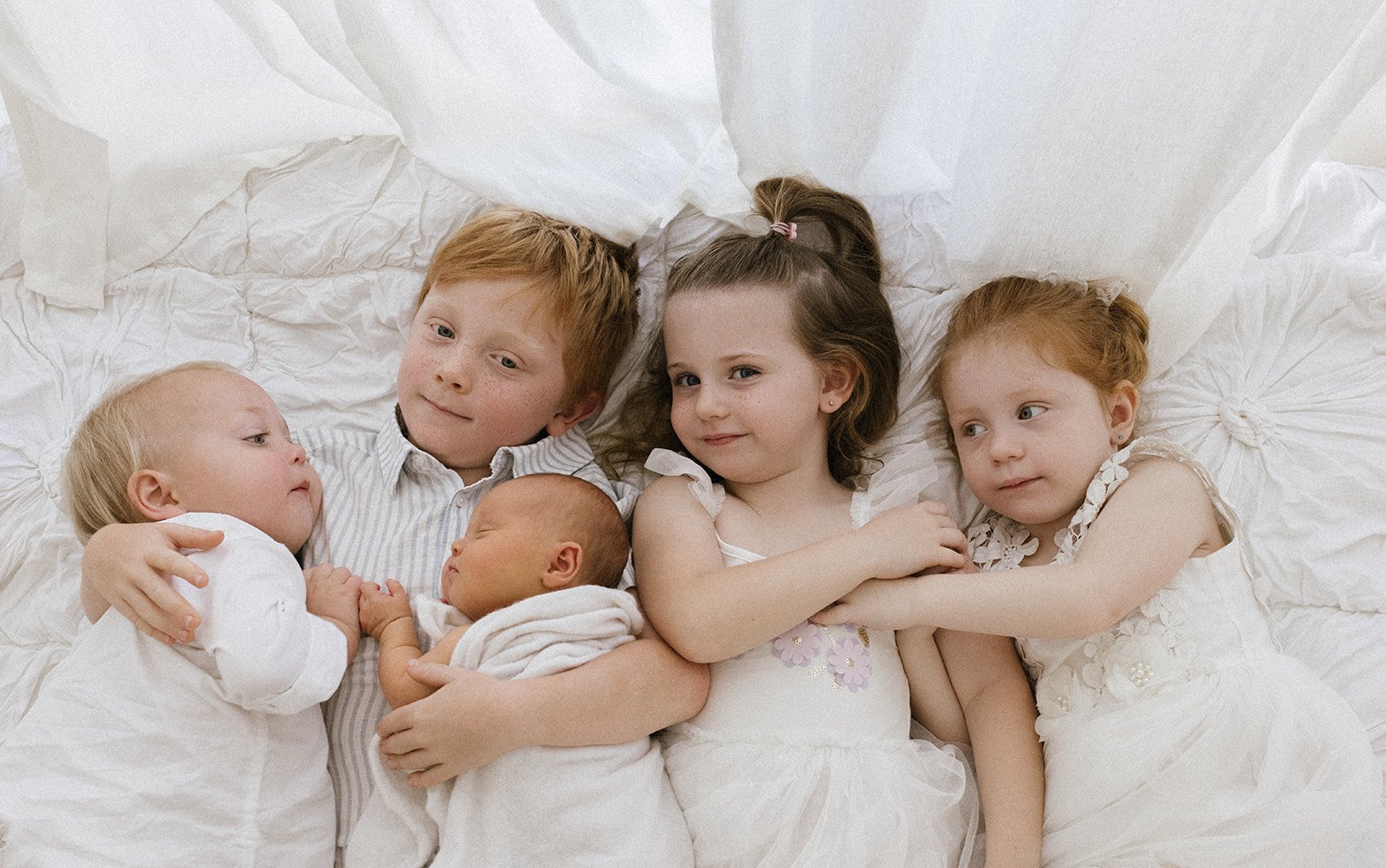Newborn baby photographed with their 4 big siblings in Brisbane newborn photography studio