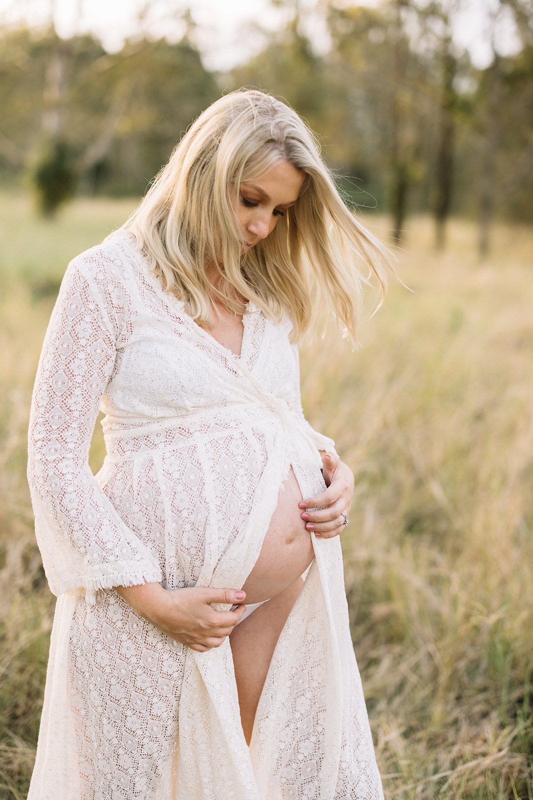 Mum to be wearing a beautiful maternity dress in a grassy field