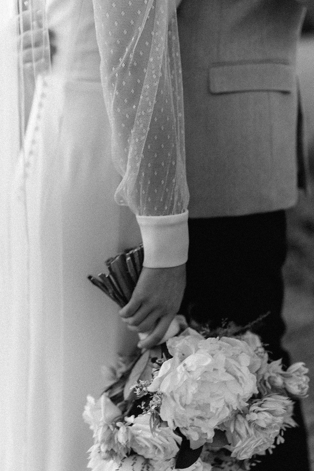  black and white detailed photograph of a wedding couple and bouqet  