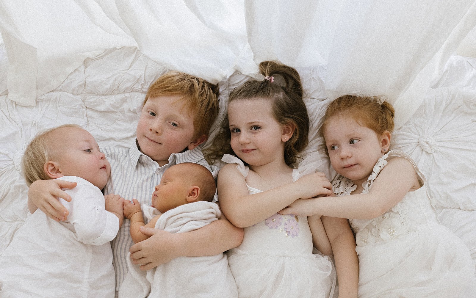 5 siblings all photographed together in Brisbane photography studio with newborn sister