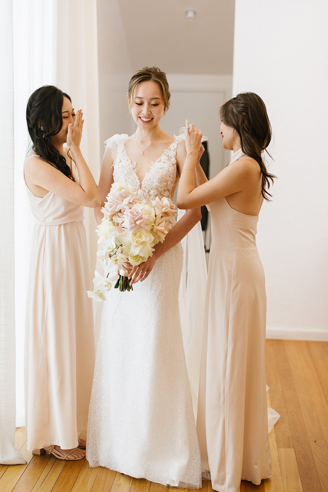  bridesmaids photographed getting the bride ready for her wedding 