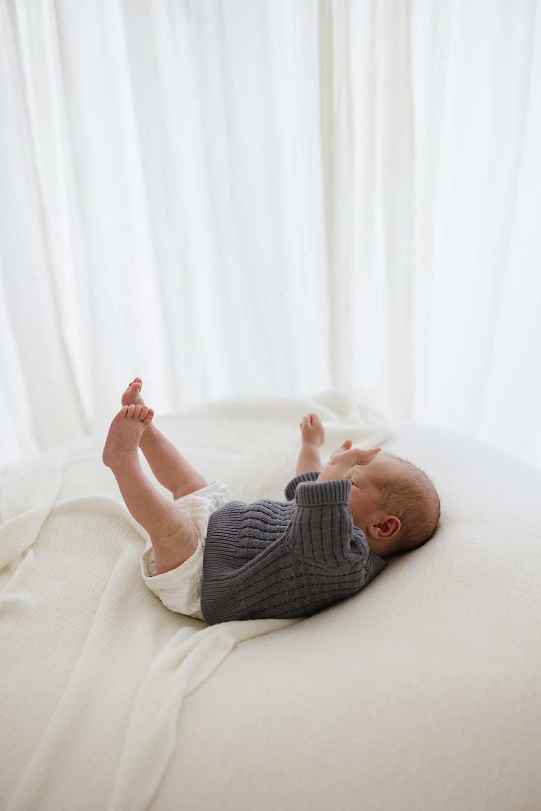  newborn baby photographed doing a big stretch  