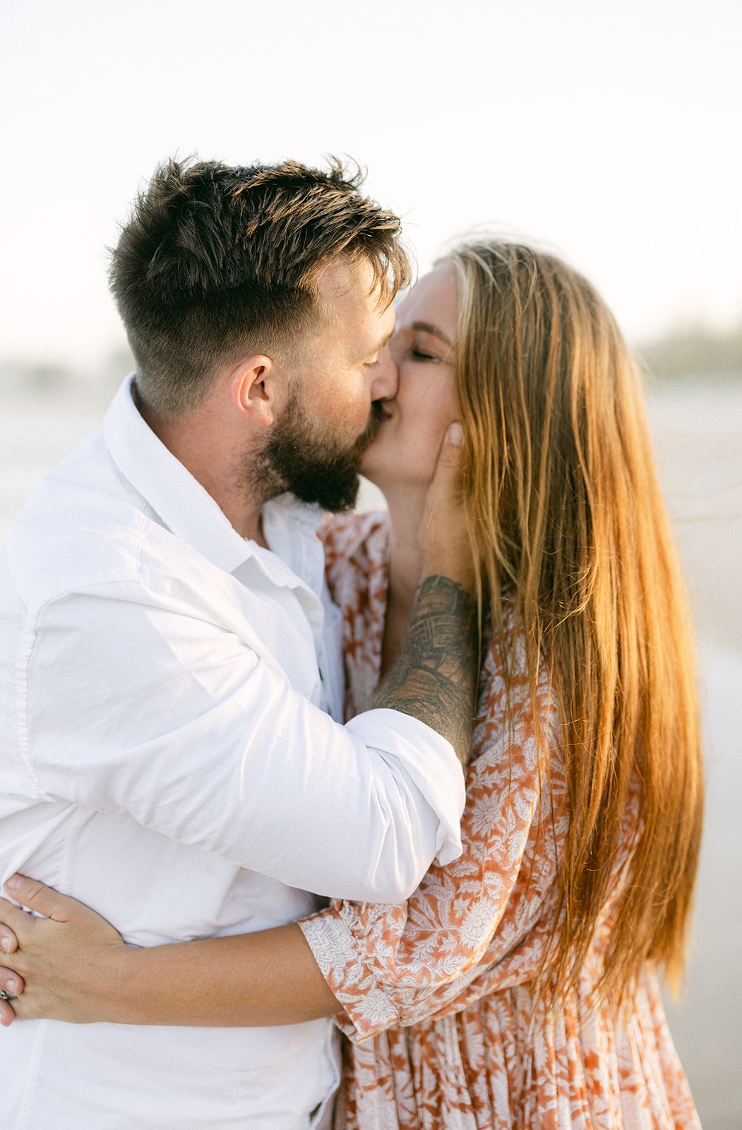 young parents kissing by the Gold Coast beach