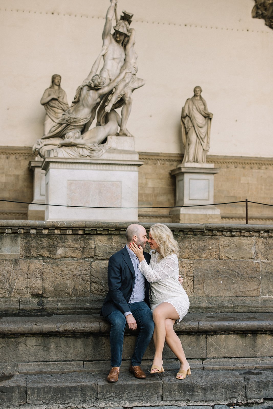 A couple kiss surrounded by Italian statues in Florence 