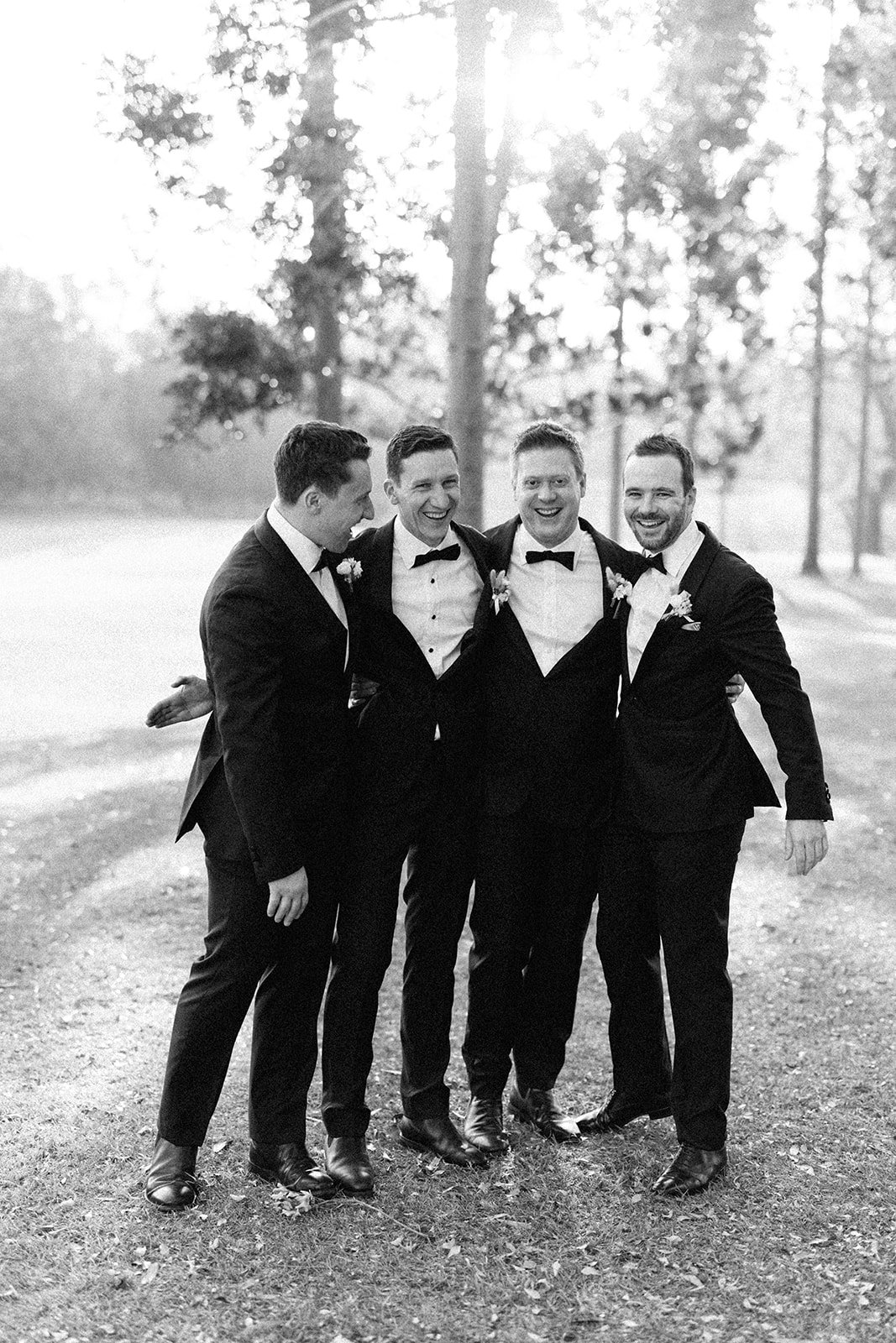 A bunch of groomsman and the groom having a laugh post ceremony