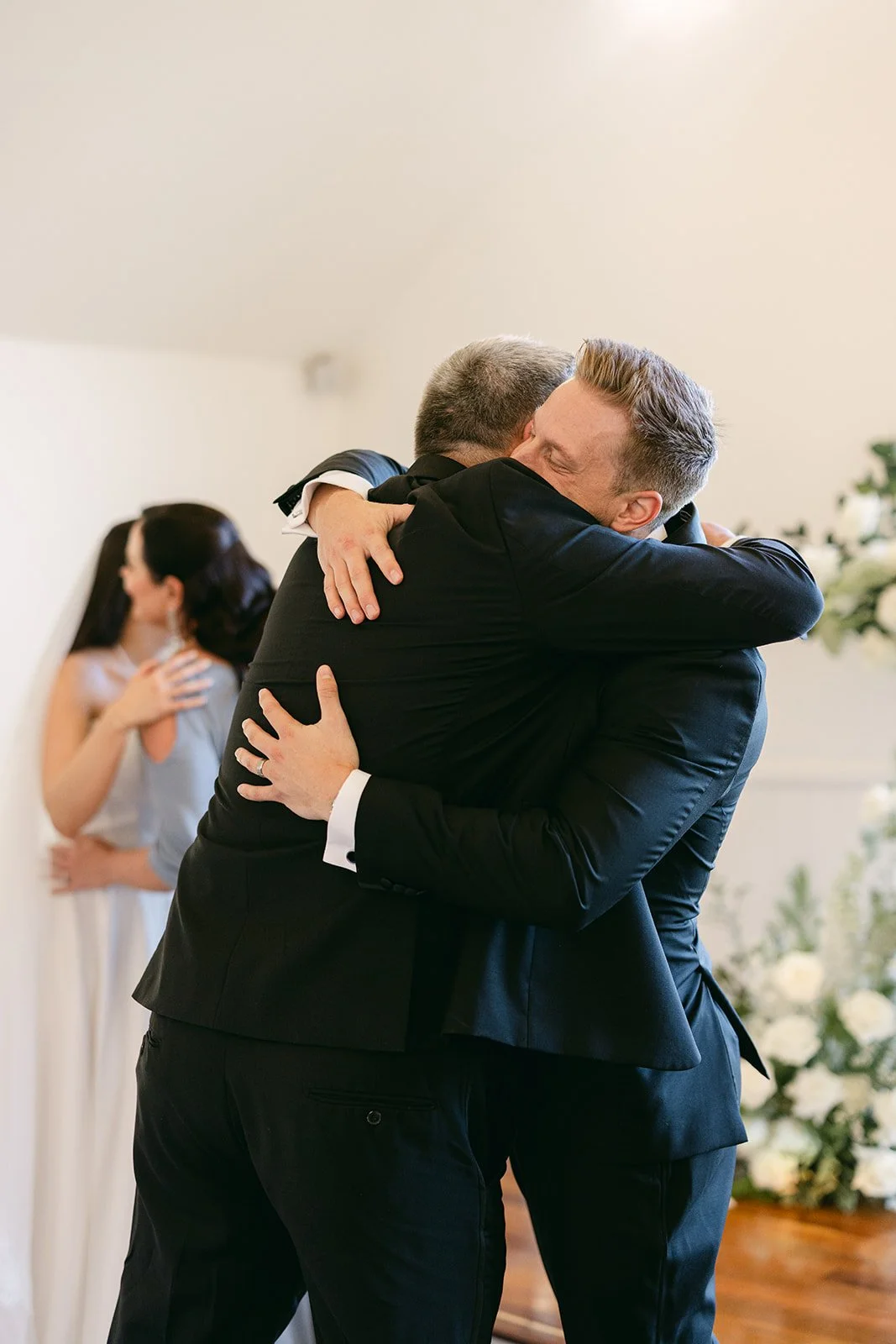 Groom exchanging a hug with father.