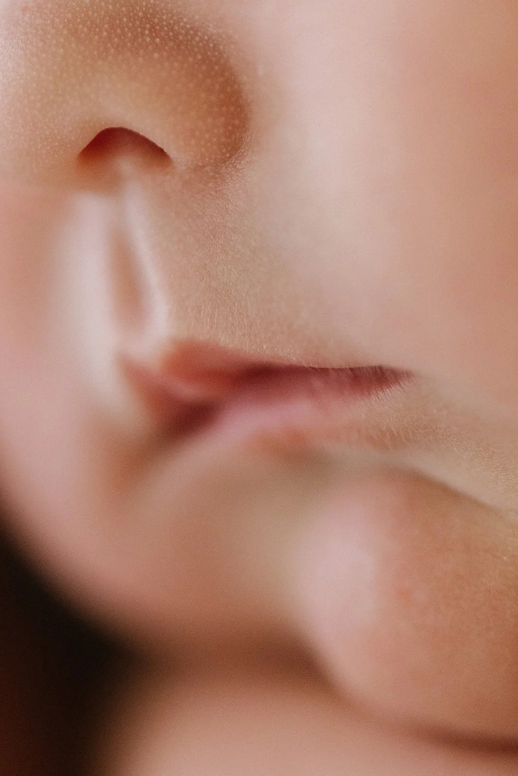 Close-up of a person's nose and lips, showing smooth skin and fine details.