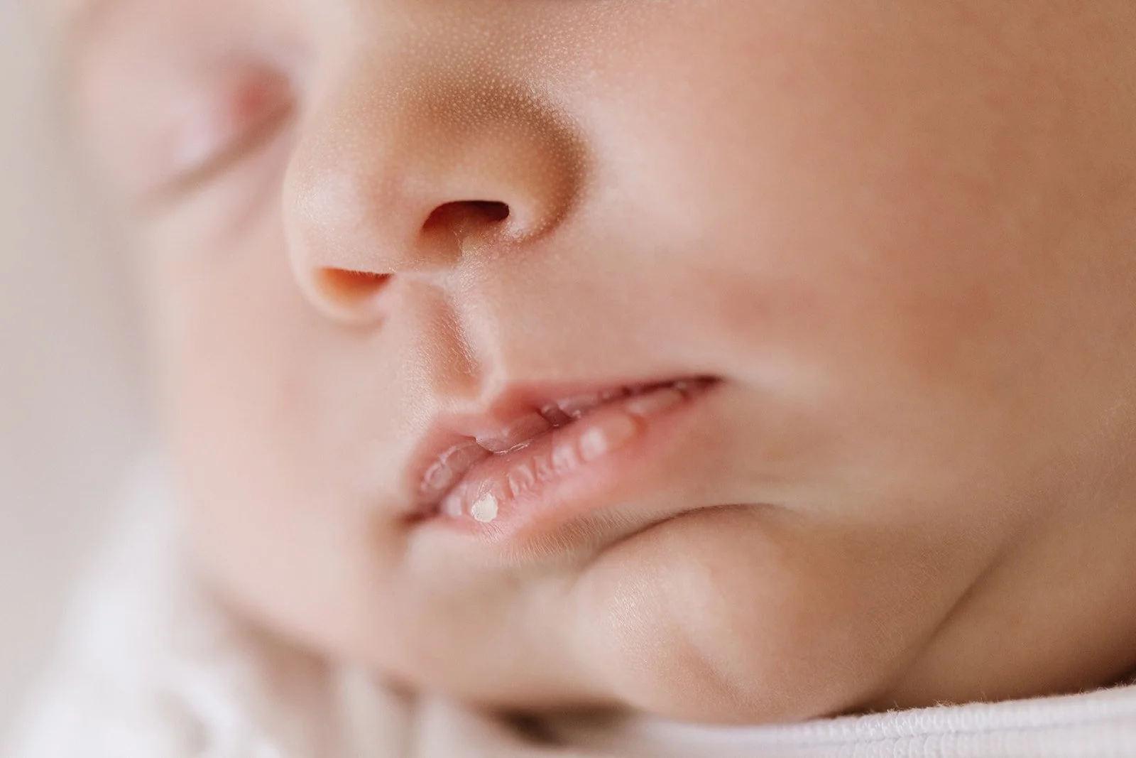 A close up photograph of newborn baby nose and lips