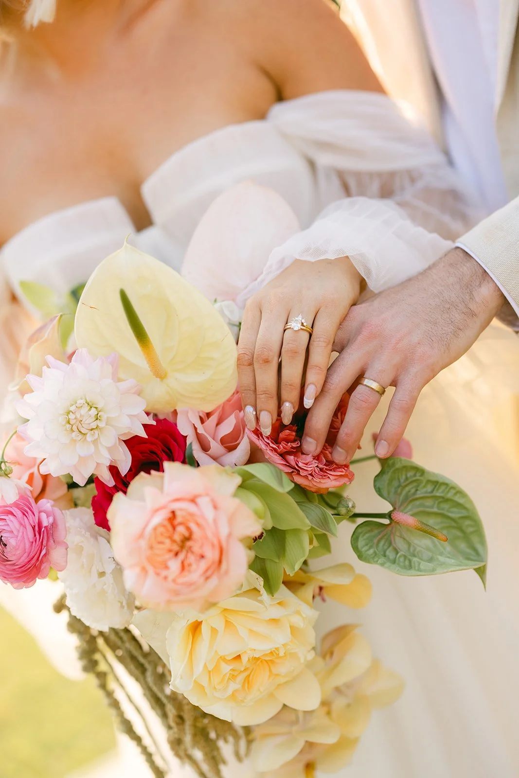 Close-up of bride and groom wedding bands and bouquet