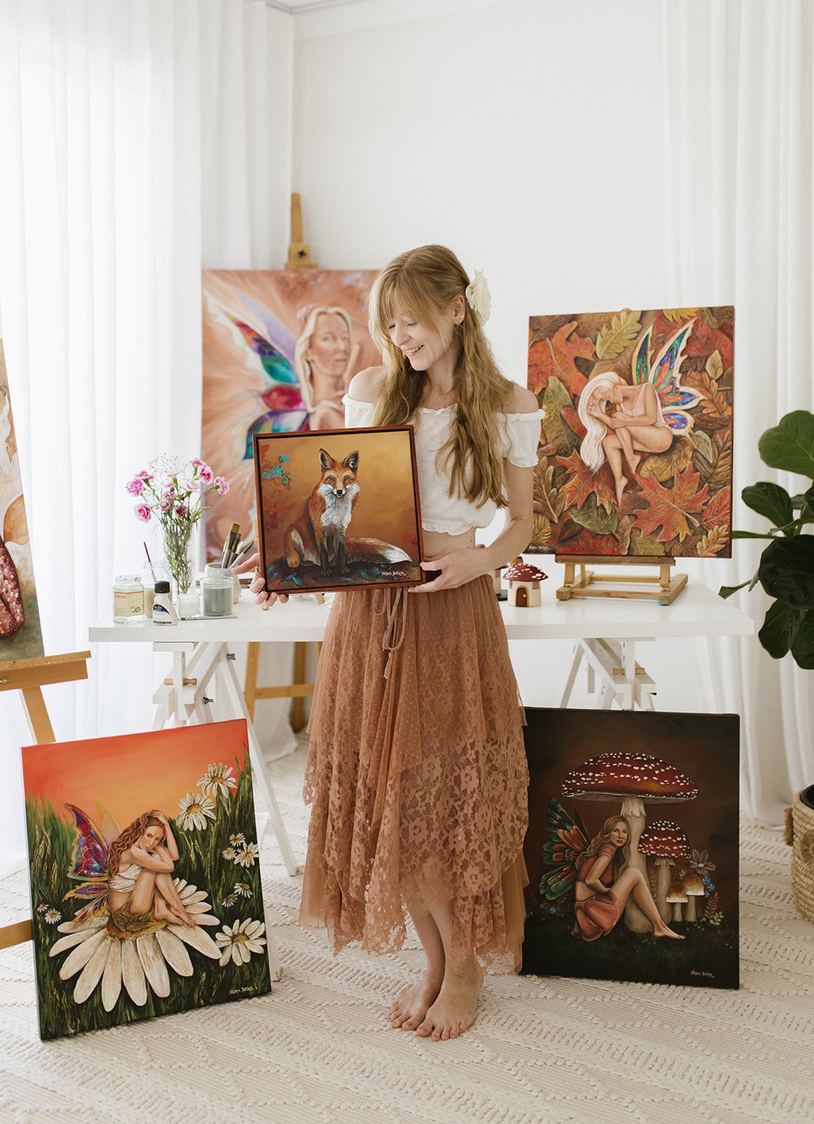 An artist is surrounded by her painting for a branding photoshoot