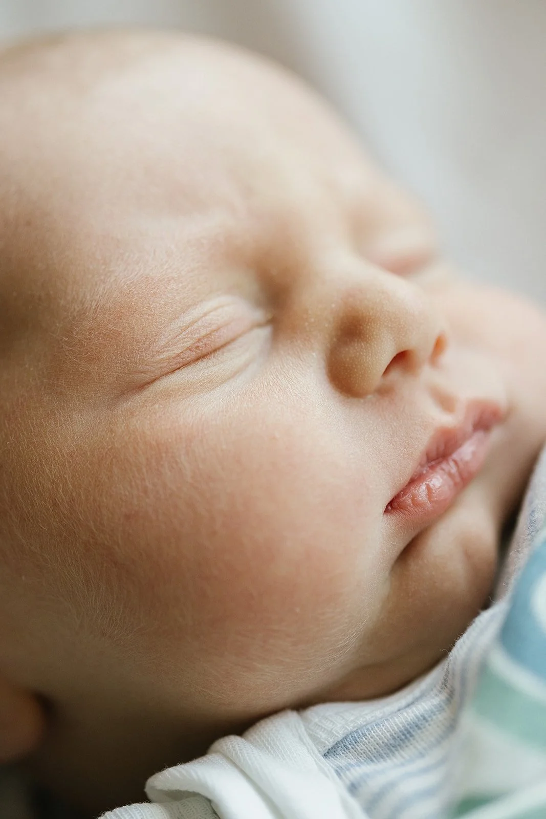 Close-up of a sleeping baby's face, focusing on the peaceful expression and soft skin.