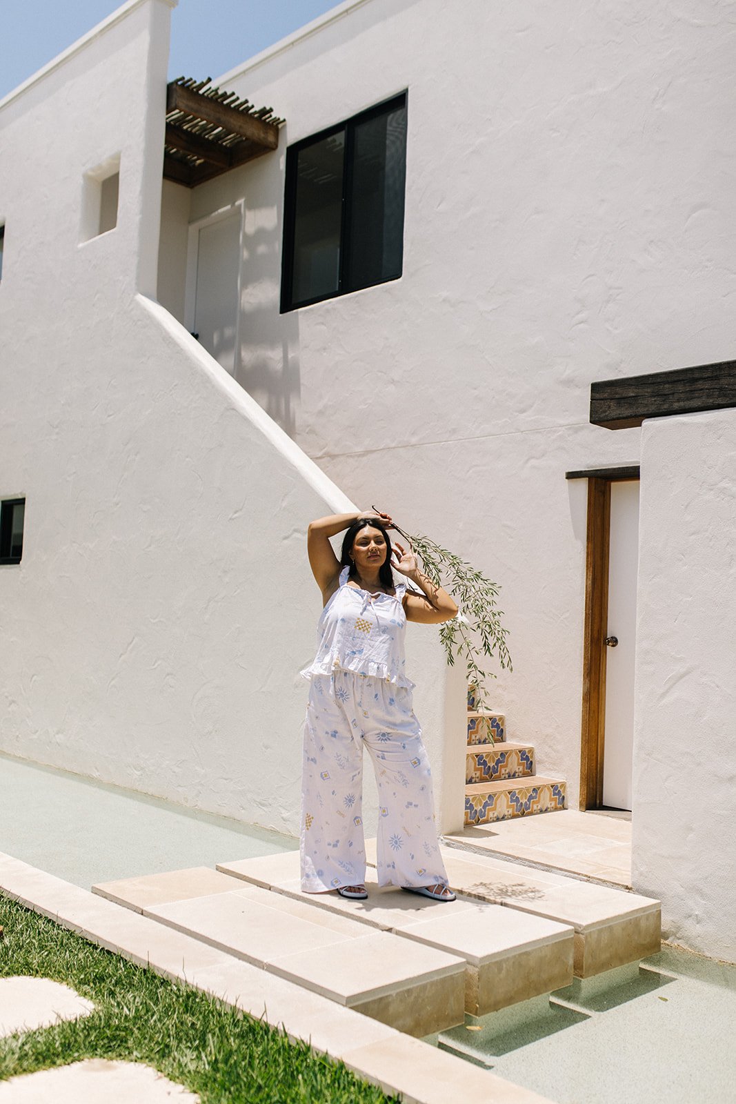 A model is standing in from of a European home for a clothing brands photography session