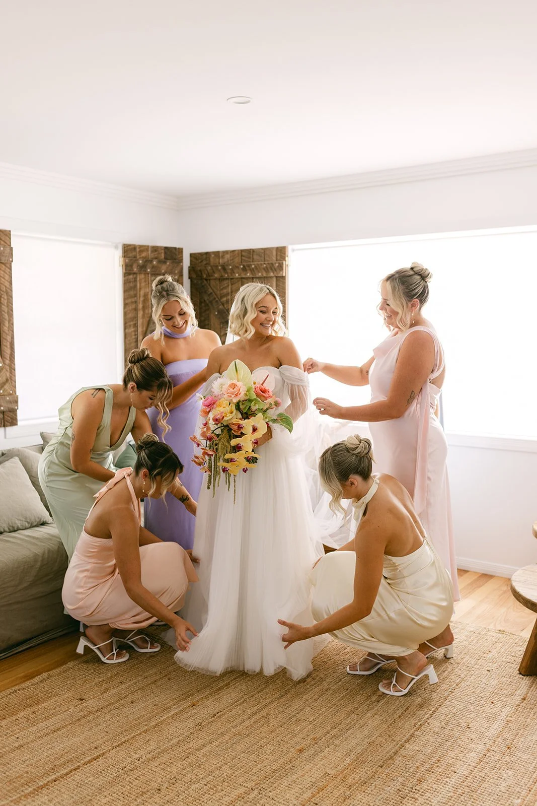 Bridesmaids assisting bride getting ready