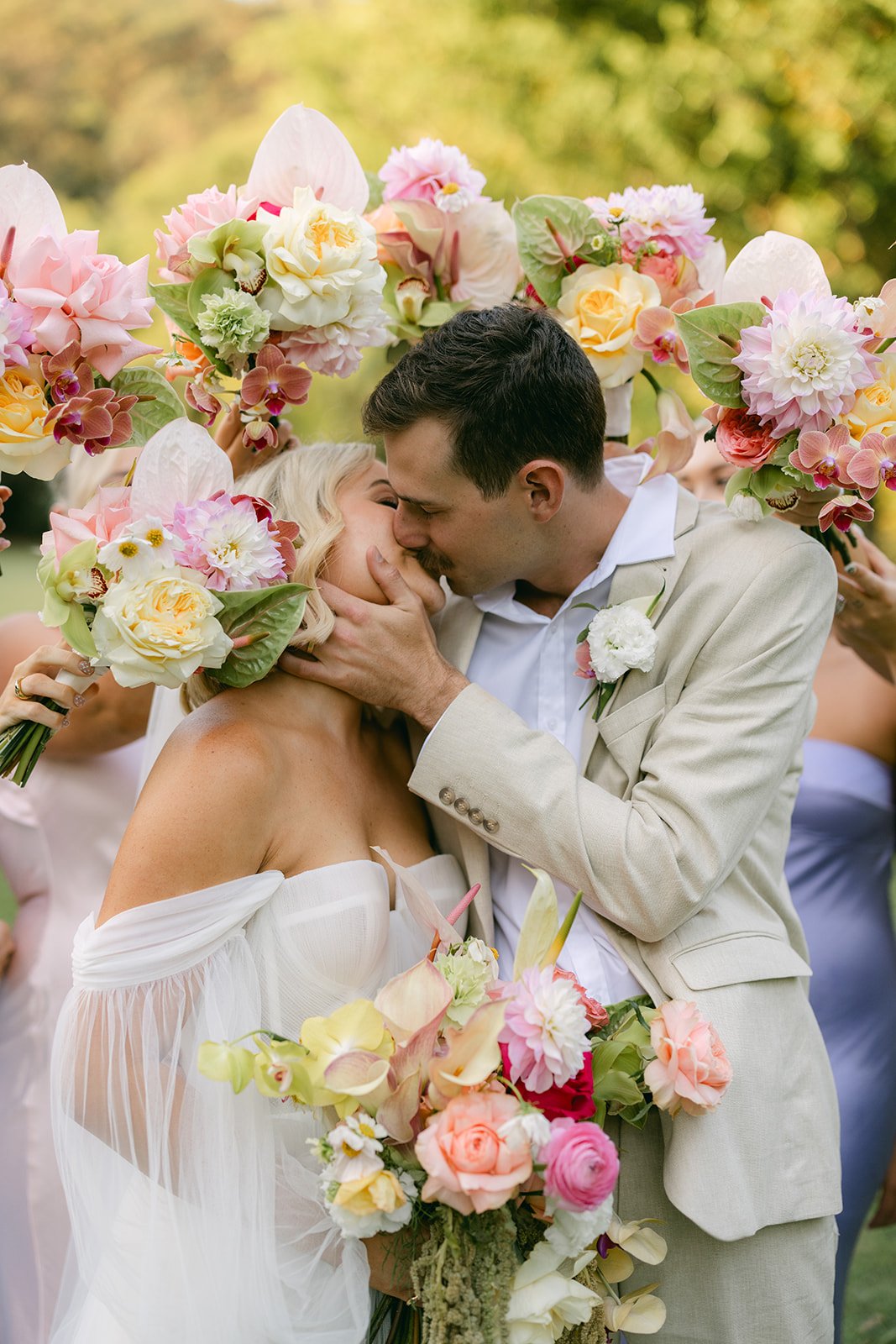 Bride and groom kissing with flowers around them