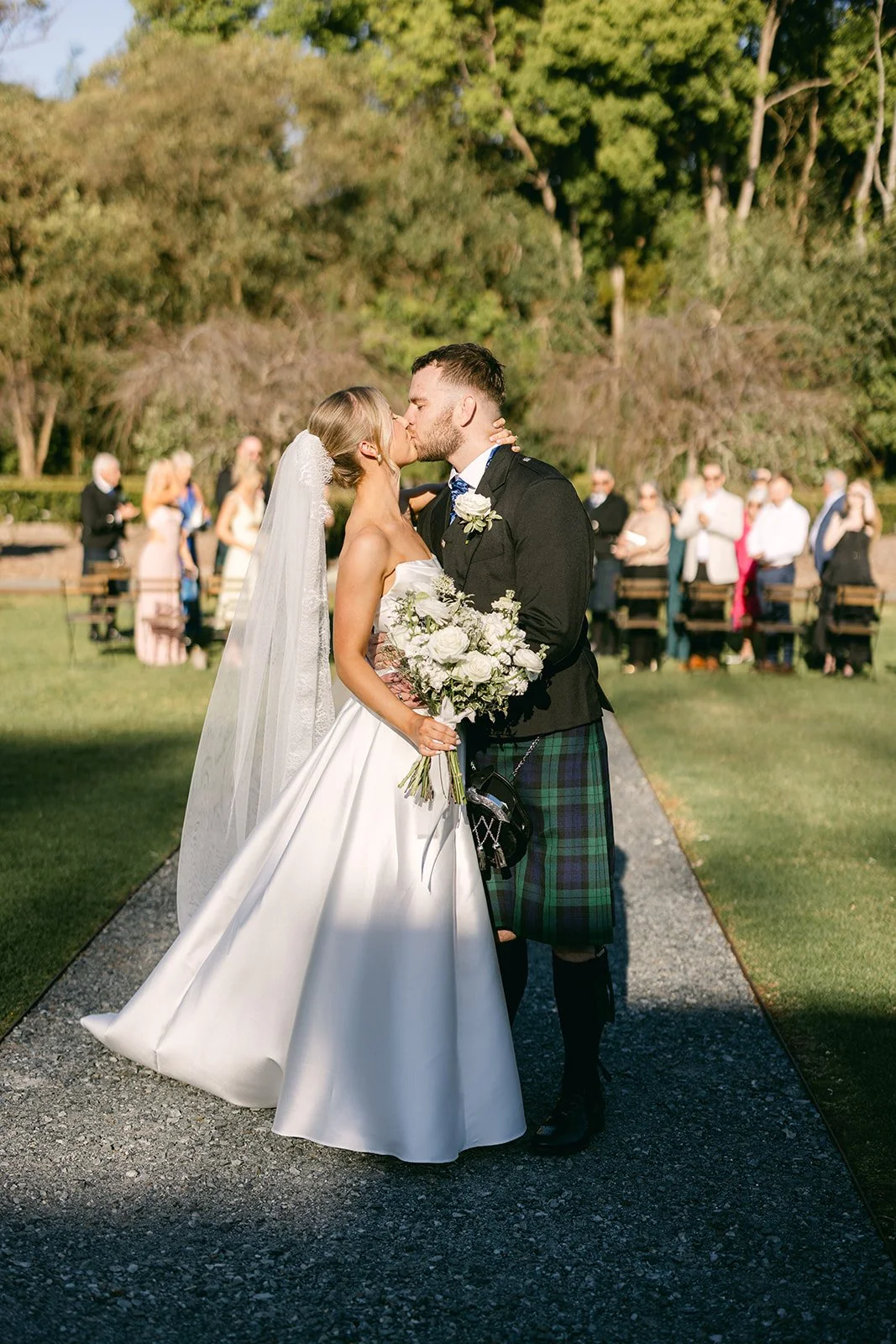 Bride and groom kissing at the end of aisle