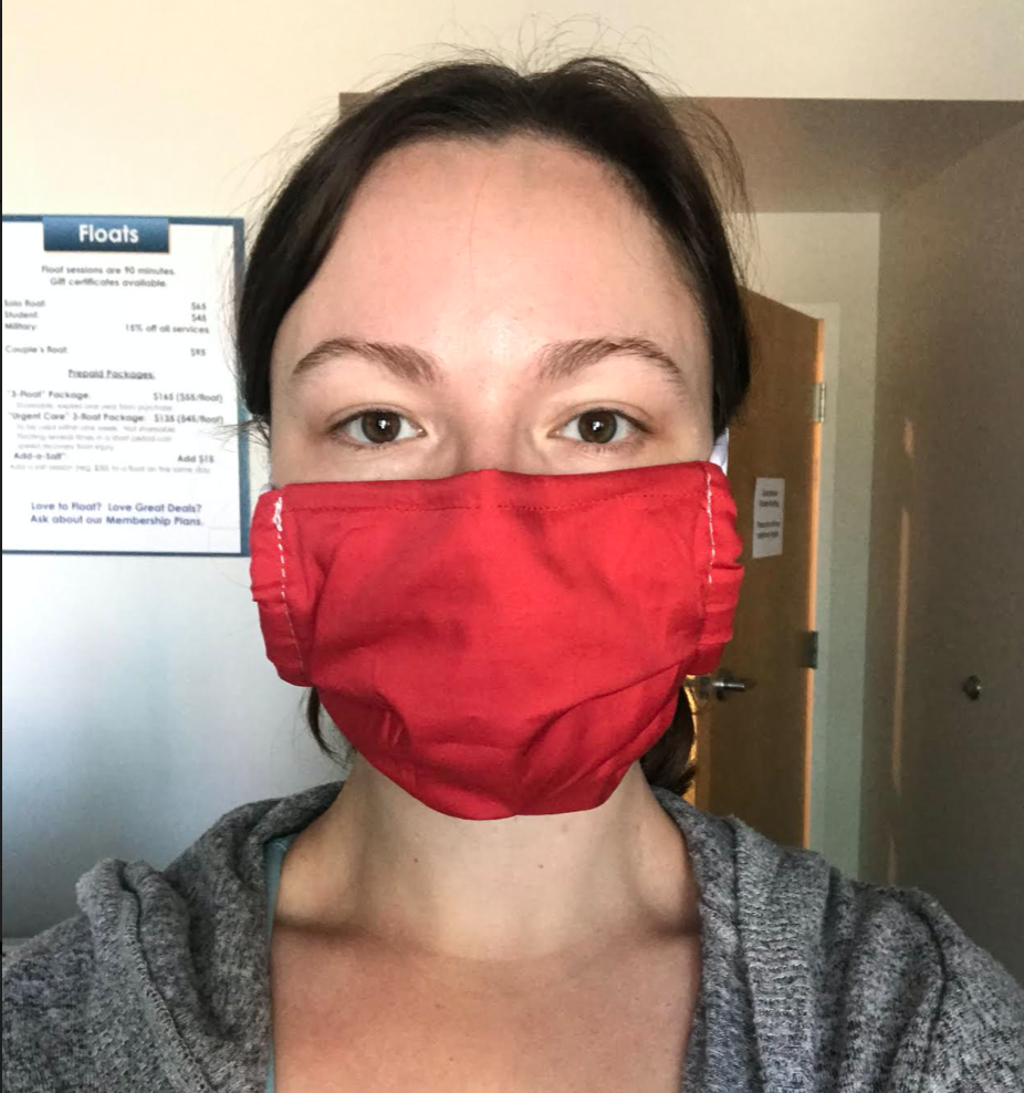 Manager Hannah modeling a mask made by the Rochester Refugees.