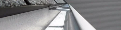 Close-up looking down a clean metal rain gutter