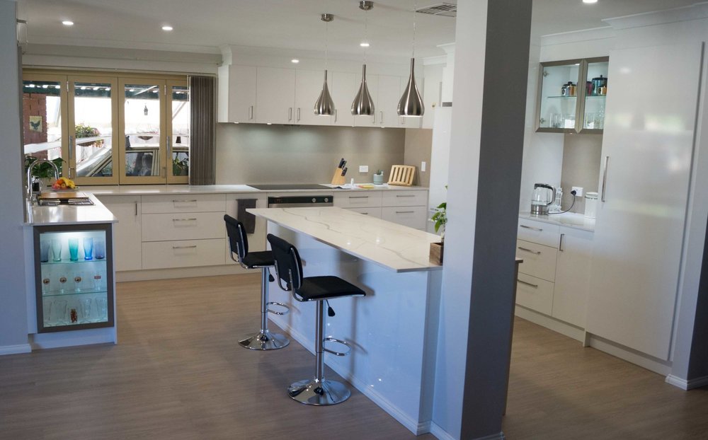 Robert & Kathy After - QN Designs Solutions 1. Removed half wall to allow for open plan kitchen design with better flow. 2. Custom size Island bench to fit space perfectly 3. Island bench to work bench space and breakfast bar to integrate in with roof support pillar. 4. Designed in more base drawers and pull out pantry drawers for more effective storage. 5. Coffee/Tea nook to isolate cooking and washing from Coffee/Tea and Toaster.