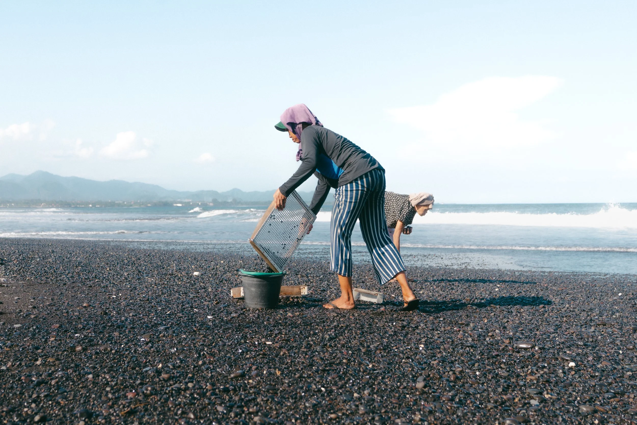  Local residents collect shells along Masceti Beach, where some community elders allege executions once took place. 