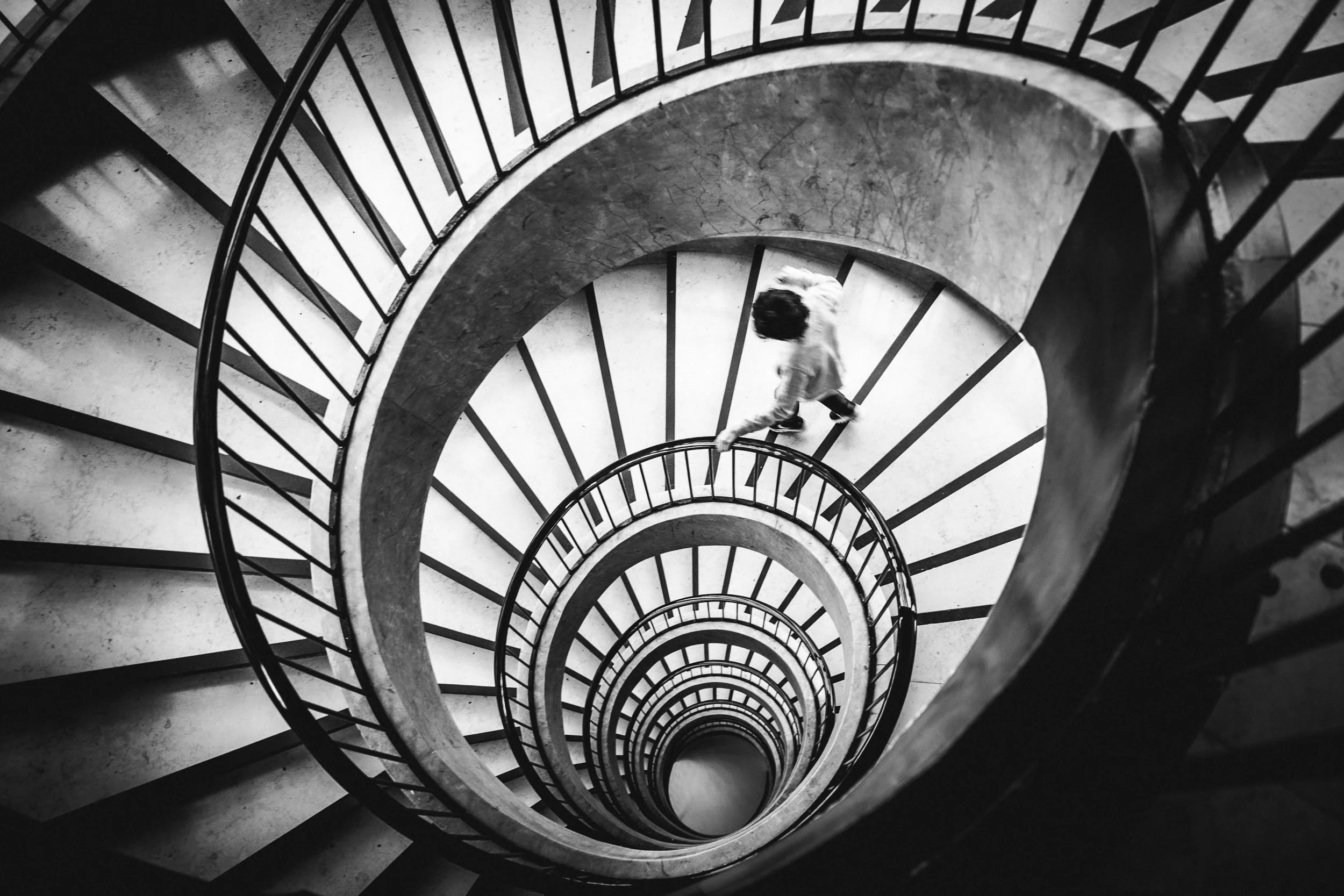 Boy running down spiral staircase by Merja Varkemaa