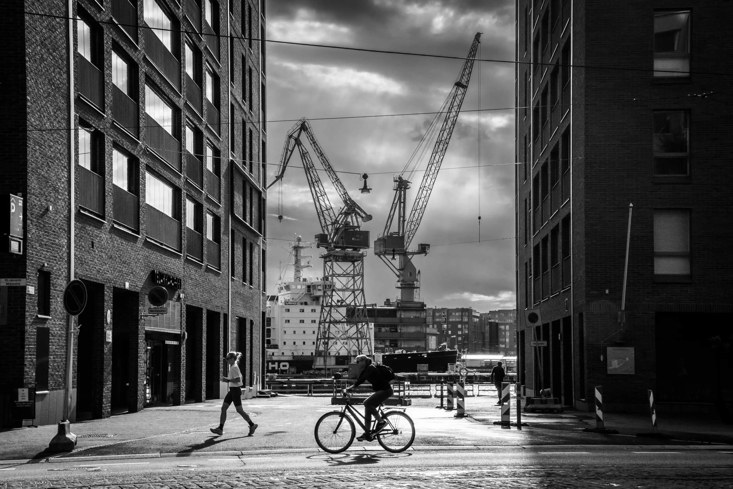 2025-21-woman-running-man-cyckling-in-contrasted-light-helsinki-merja-varkemaa.jpg