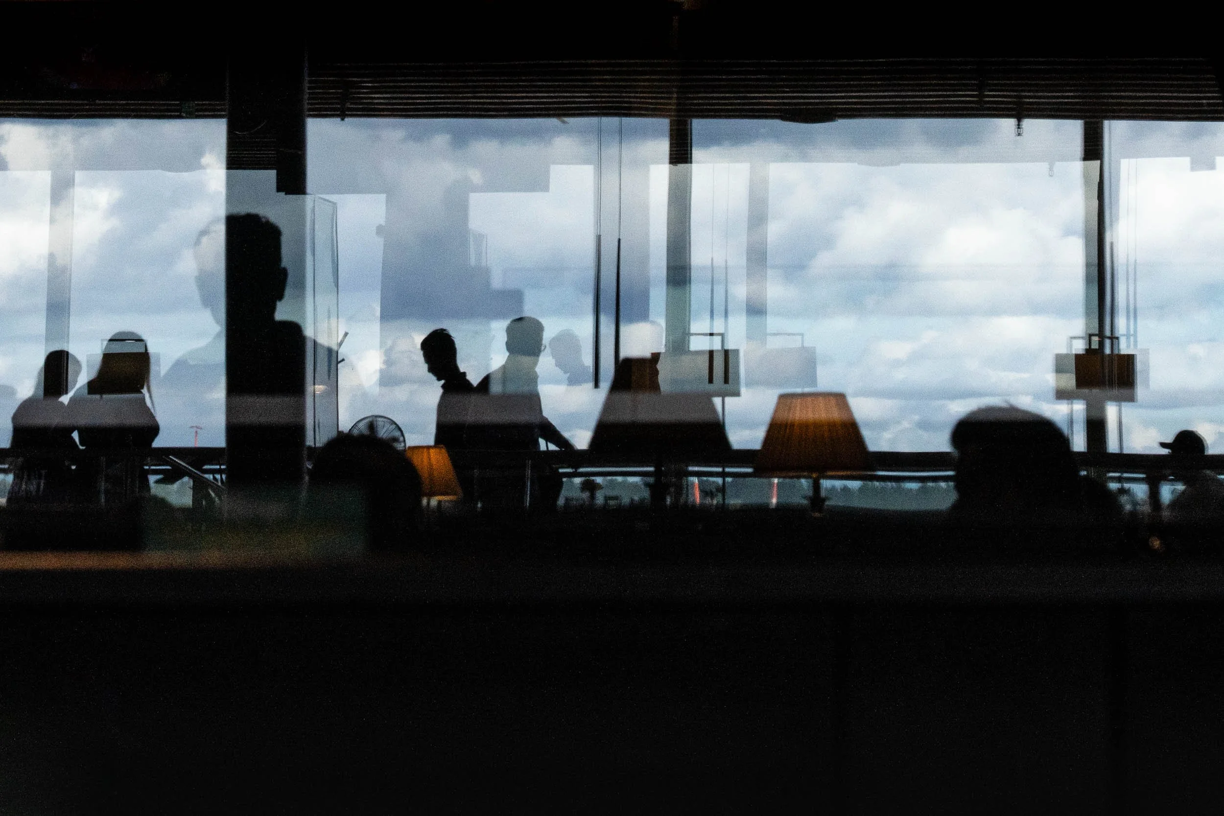 2025-23-people-reflecting-on-window-helsinki-airport-merja-varkemaa.jpg