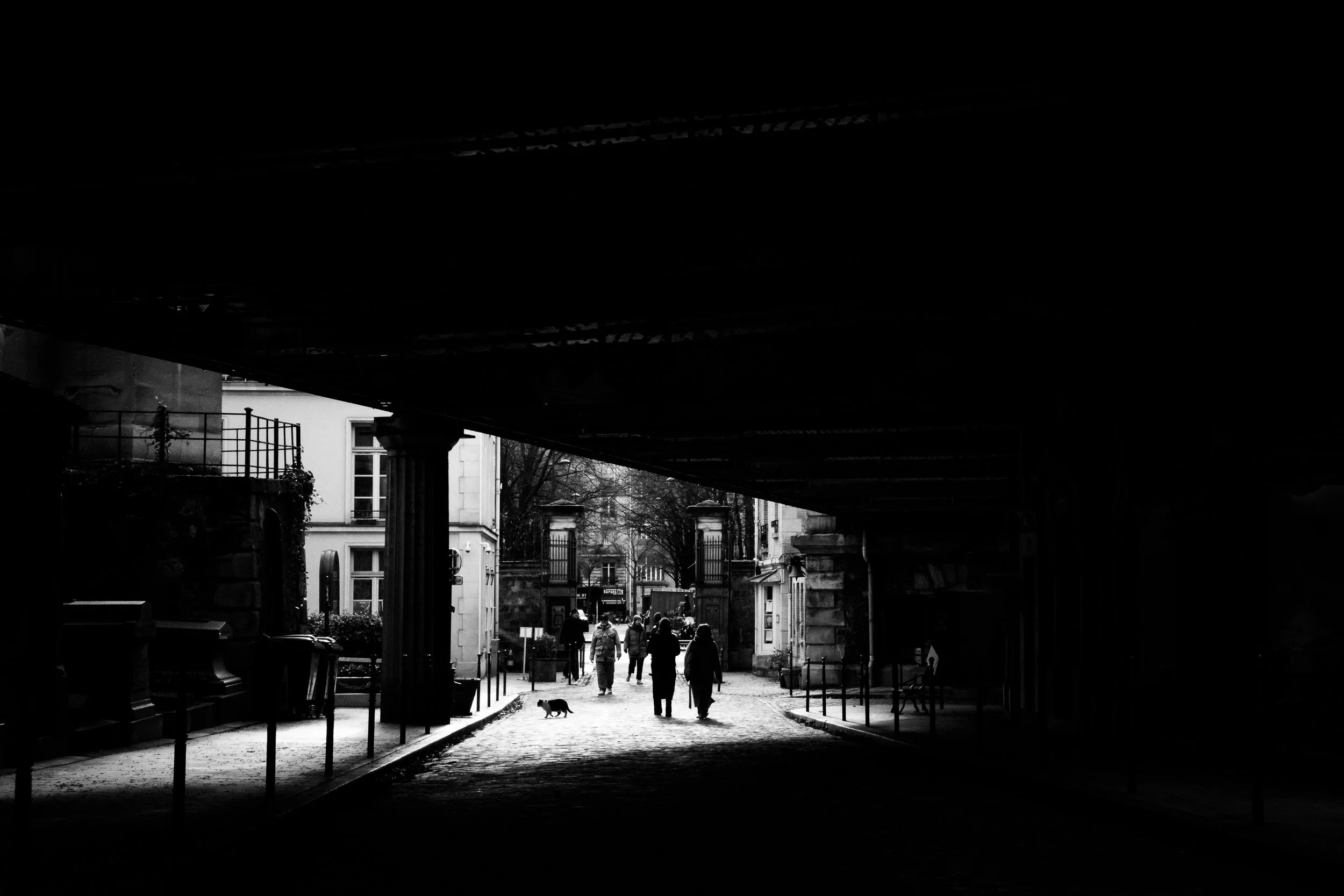 2-people-walking-under-bridge-montmartre-cemetery-black and white-merja varkemaa photography.jpg