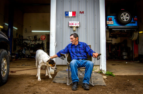 Marcel Richard sits outside of the mechanic shop that he and his family runs in their backyard, in Rogersville, NB. The land was purchased by Richard's father in 1938 and has remained in the family ever since.