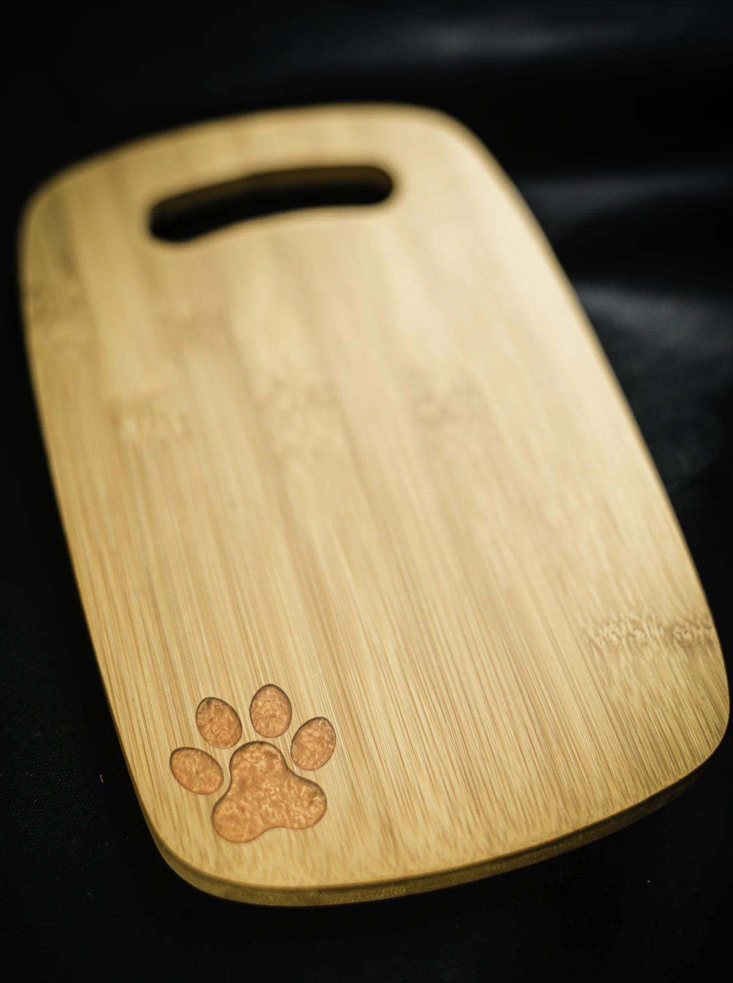 custom laser engraved paw print orange epoxy filled bamboo serving board