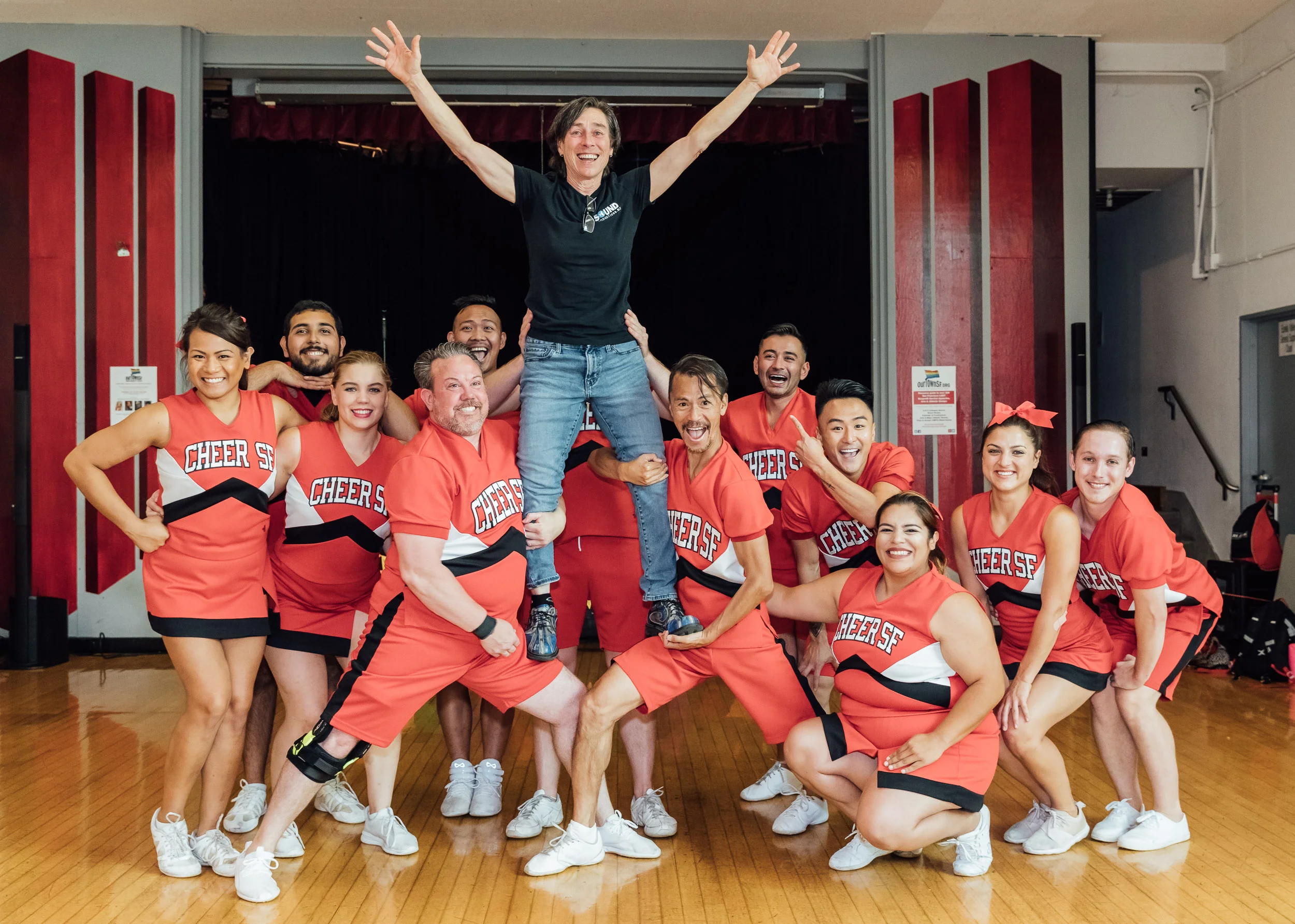 Cheer SF posing with an attendee of a community event by Lor Photo