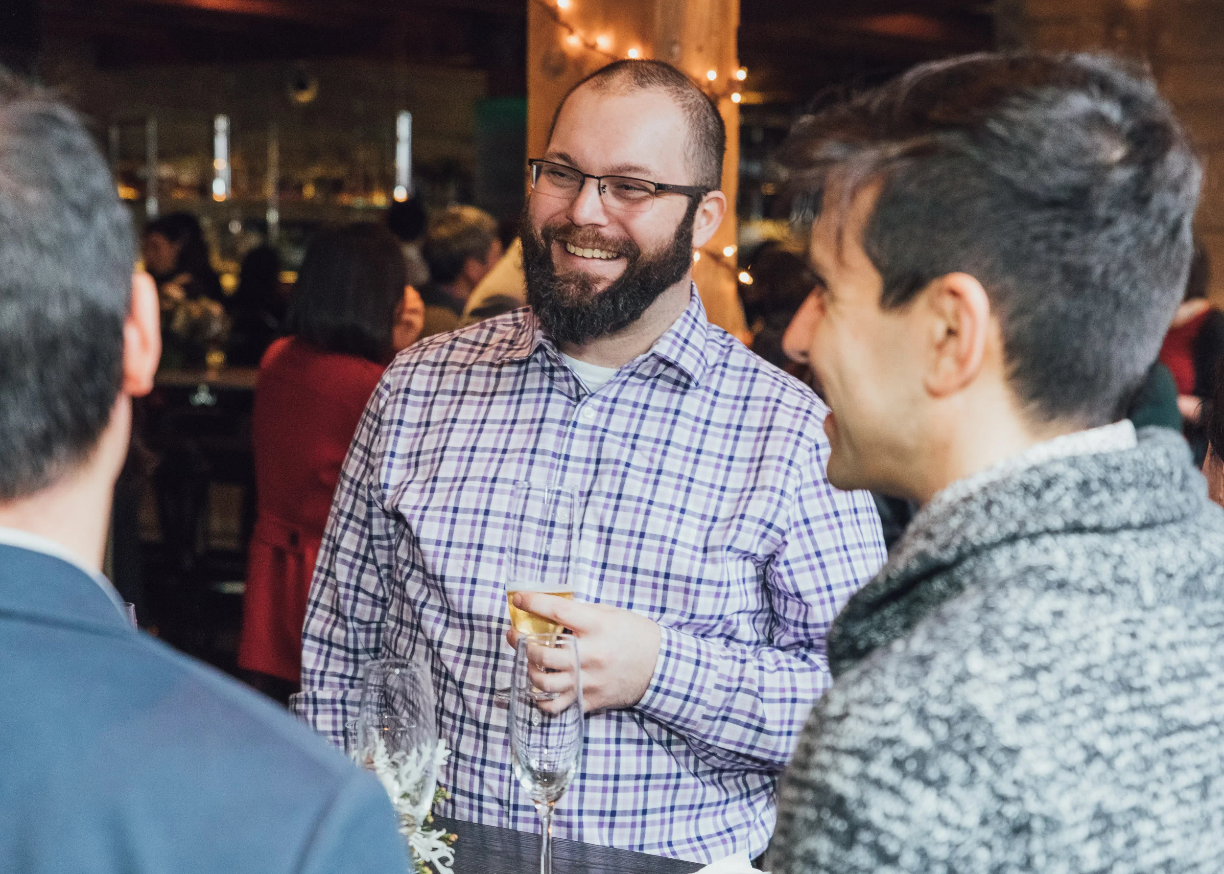 Coworkers catching up at holiday party by Lor Photo