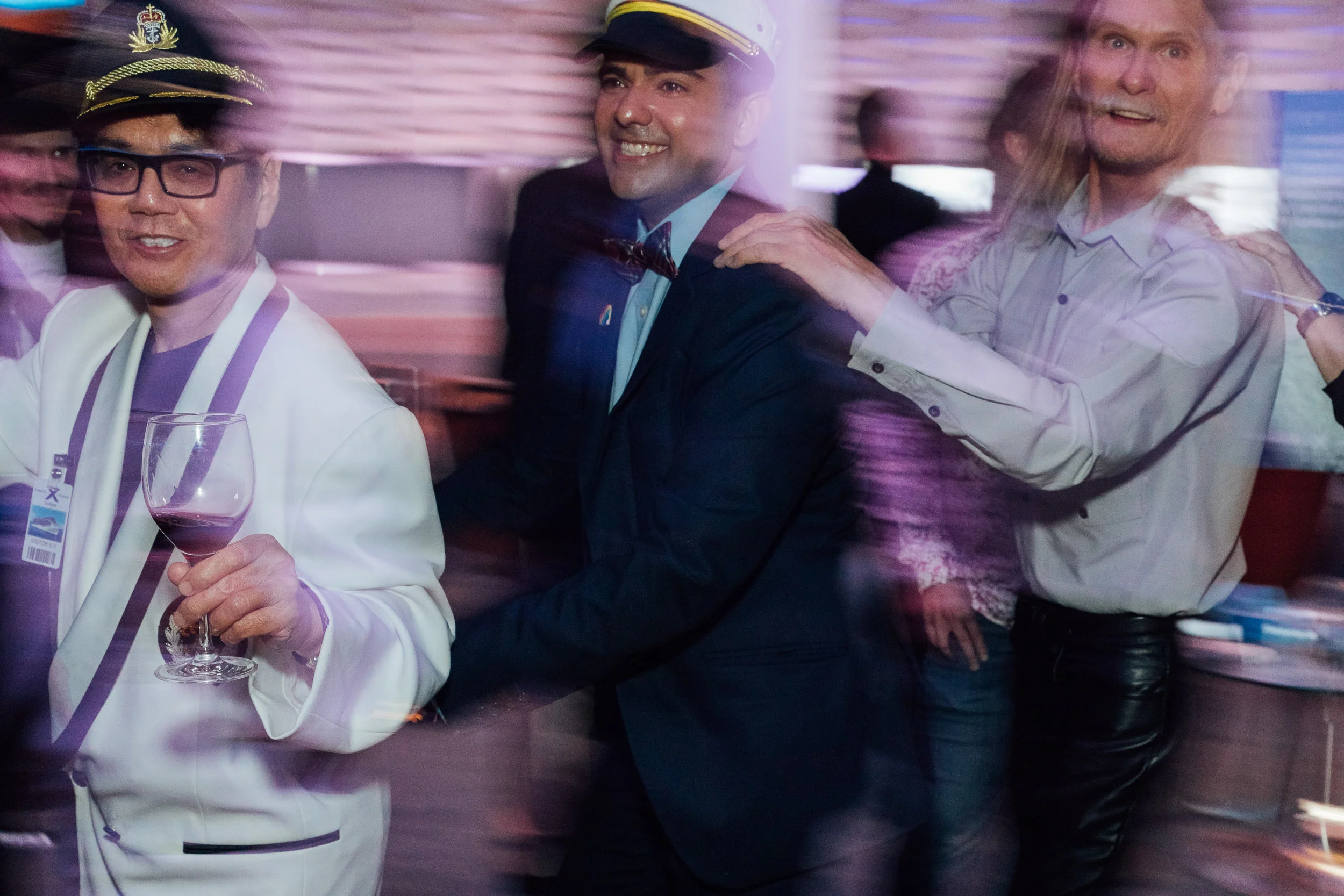 Partygoers dancing in a conga line, by Lor Photo