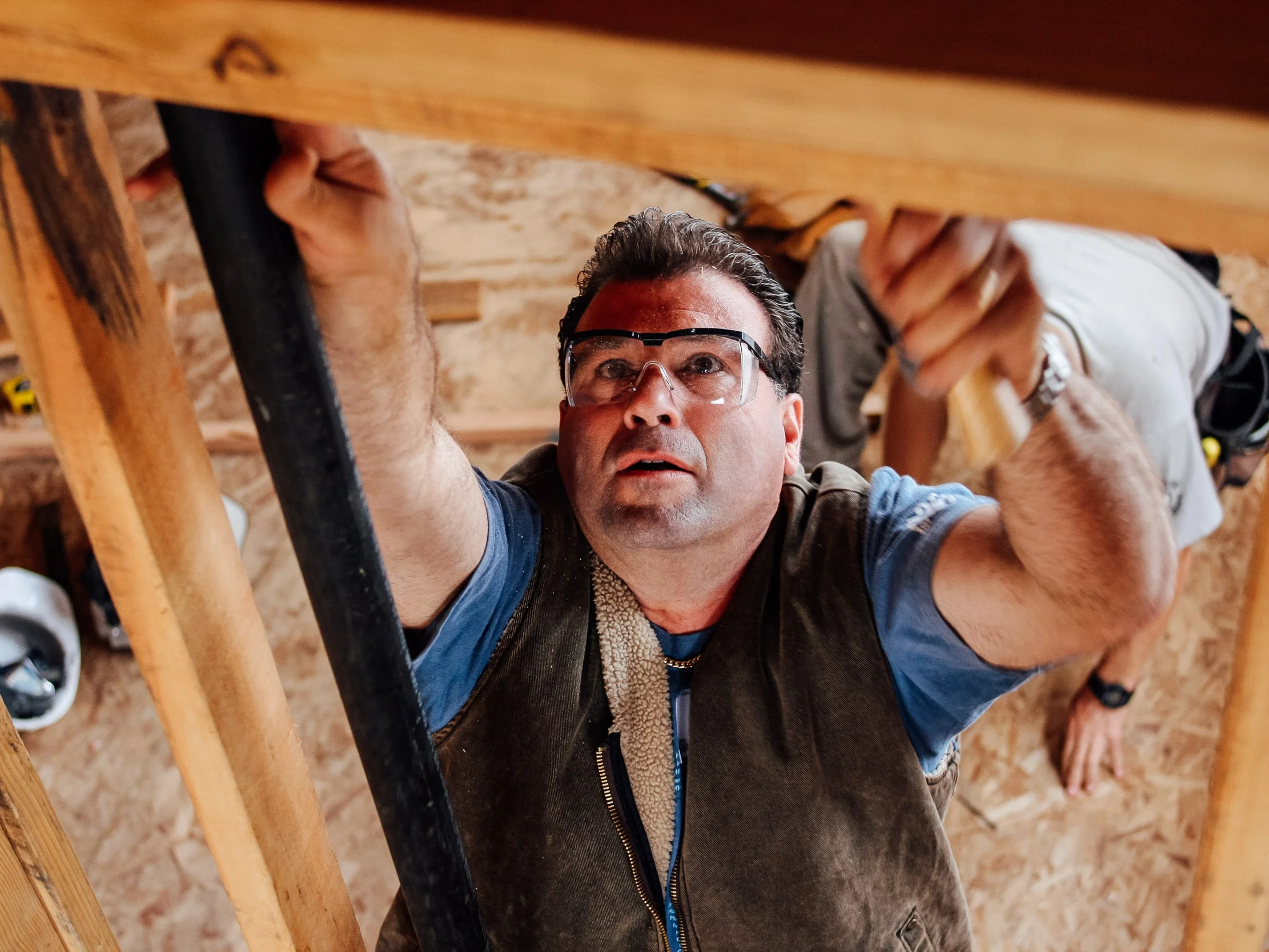 Volunteer swinging a hammer during a Habitat for Humanity build by Lor Photo