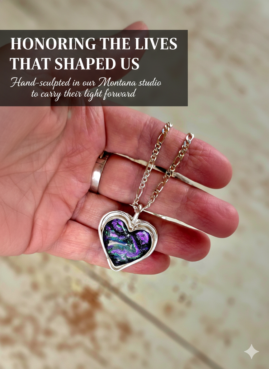 A hand holding a handcrafted glass memorial heart pendant with vibrant purple and green swirls, representing the cherished legacy of a loved one.
