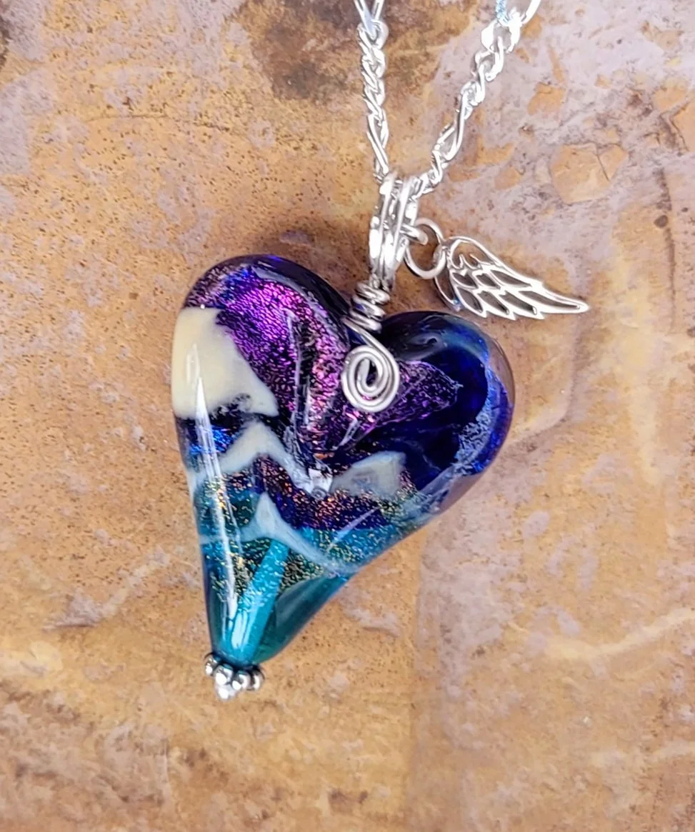 Handcrafted sterling silver memorial pendant featuring a deep blue 'Sacred Trace' glass infusion, displayed as a timeless tribute for a cherished loved one