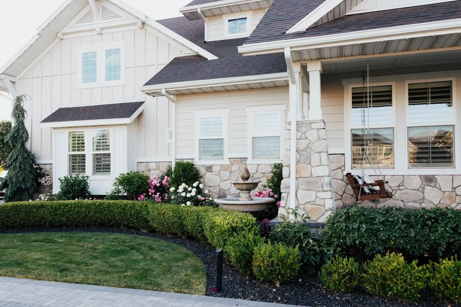 Front yard landscape maintenance with trimmed hedges and flower beds in Salt Lake City, UT