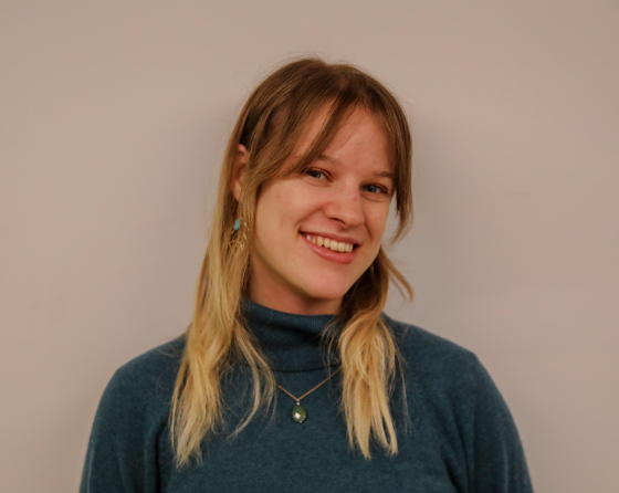 Headshot of the author wearing a blue sweater and smiling at the camera.